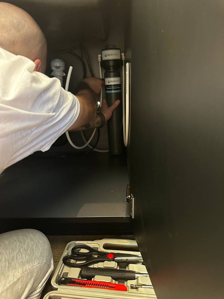 Under-sink supply lines reconnected with hand tools laid out — plumbing repair service in Denver