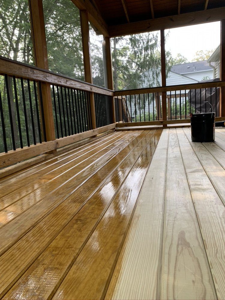 Rebuilt deck boards freshly coated and drying under a covered porch — deck repair service in Denver
