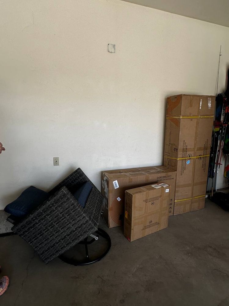 Boxed flat-pack patio furniture stacked in a garage before assembly — furniture assembly in Denver