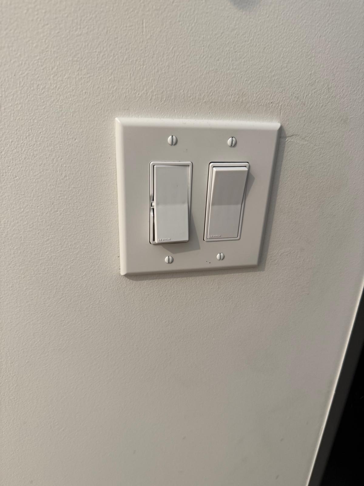 New double light switch plate sitting flush on a finished wall — electrical fixture installation service in Denver