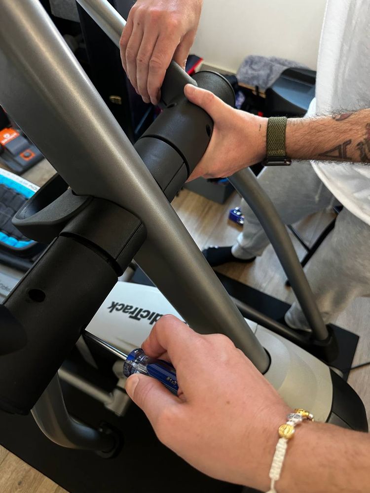 Exercise machine frame being bolted together from the manual — equipment assembly service in Denver
