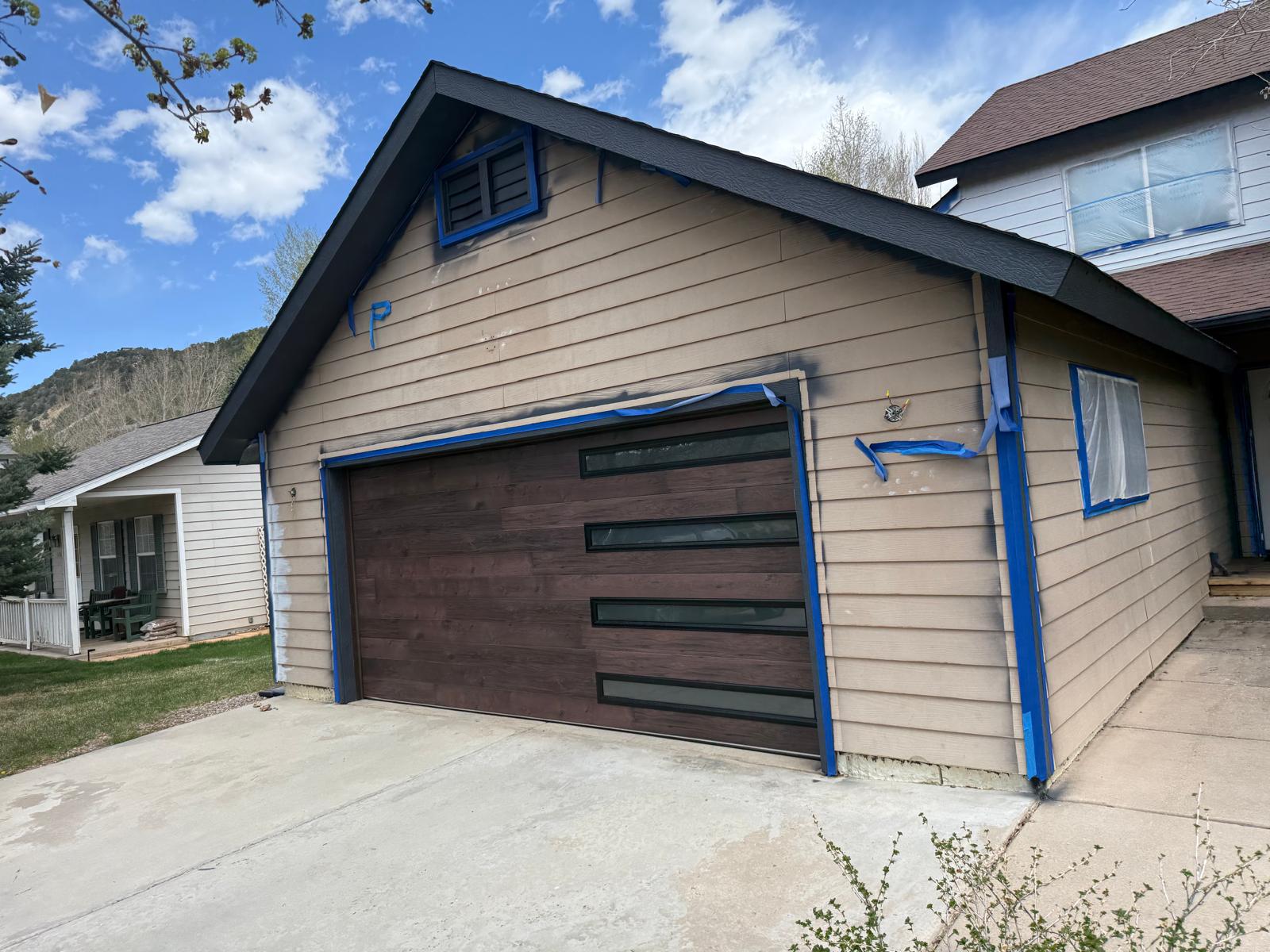 Repainted garage elevation with masked trim removed and paint cured — exterior painting service in Denver