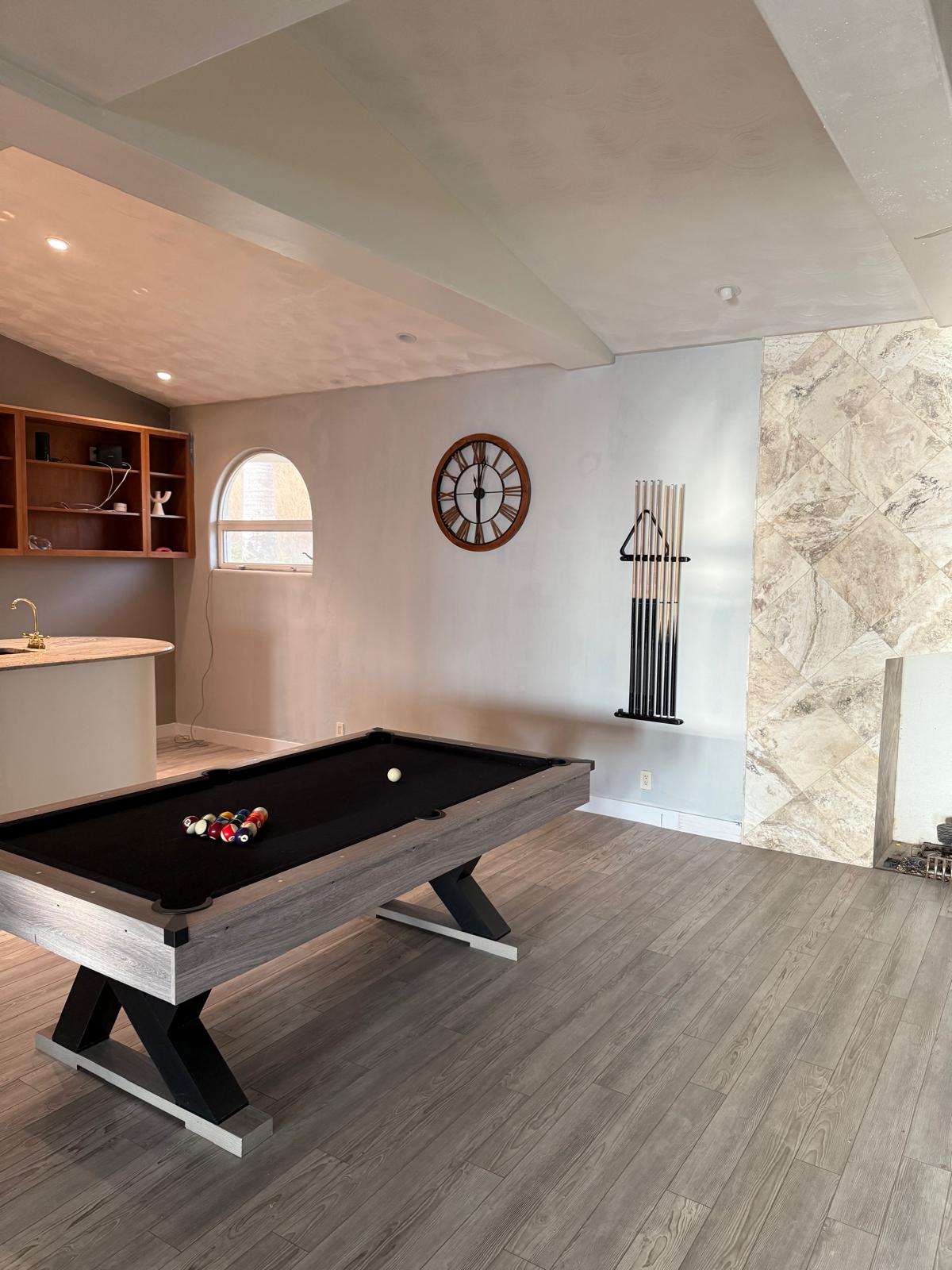 Finished game room after interior repaint — clean walls, vaulted ceiling, pool table — painting in Denver