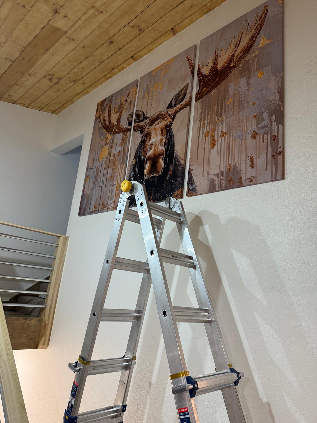 Large three-panel artwork hung level on a textured wall above a stair rail — picture and fixture mounting service in Denver