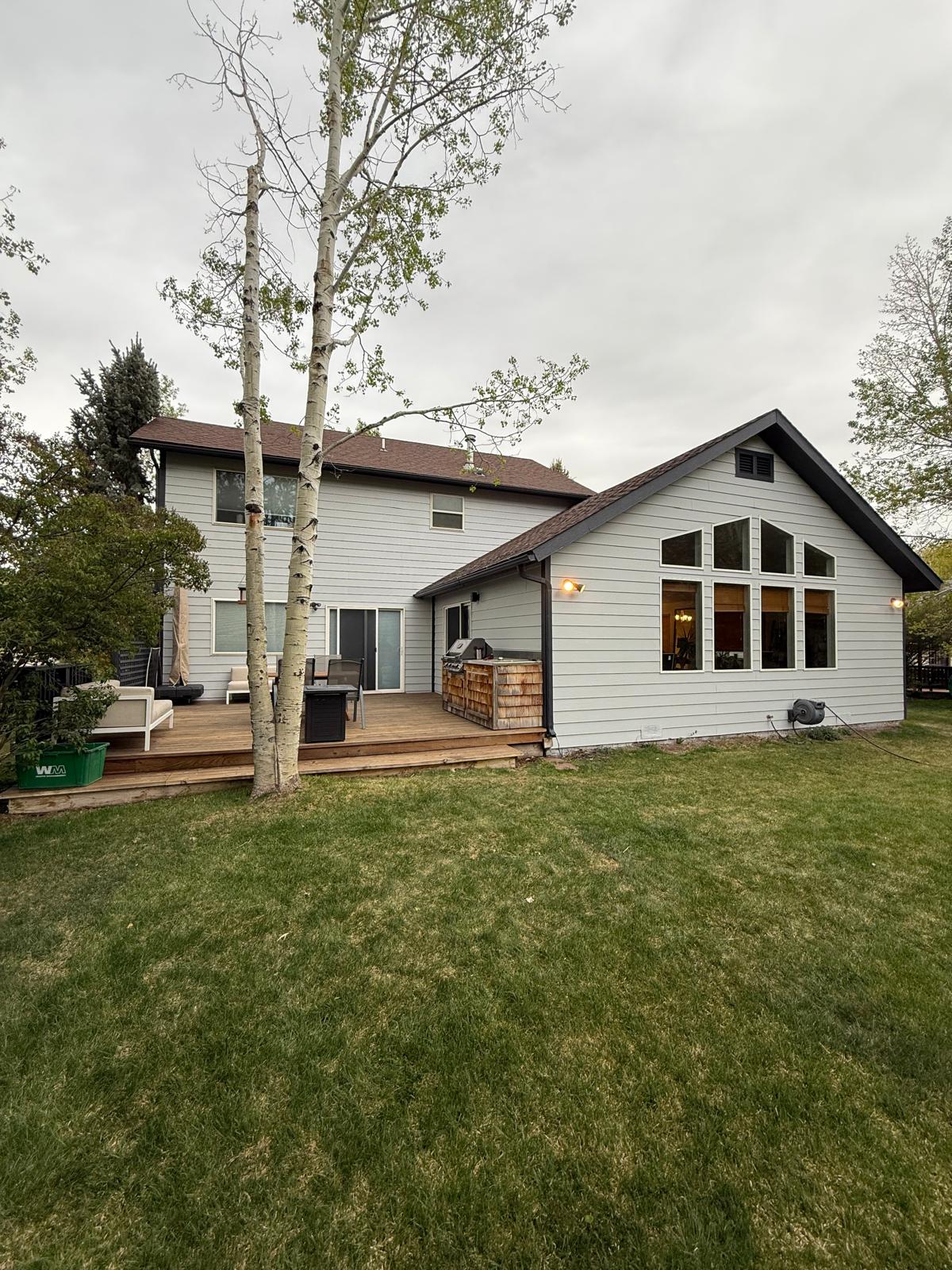 Single-storey home with finished light siding and dark trim — exterior painting service in Denver