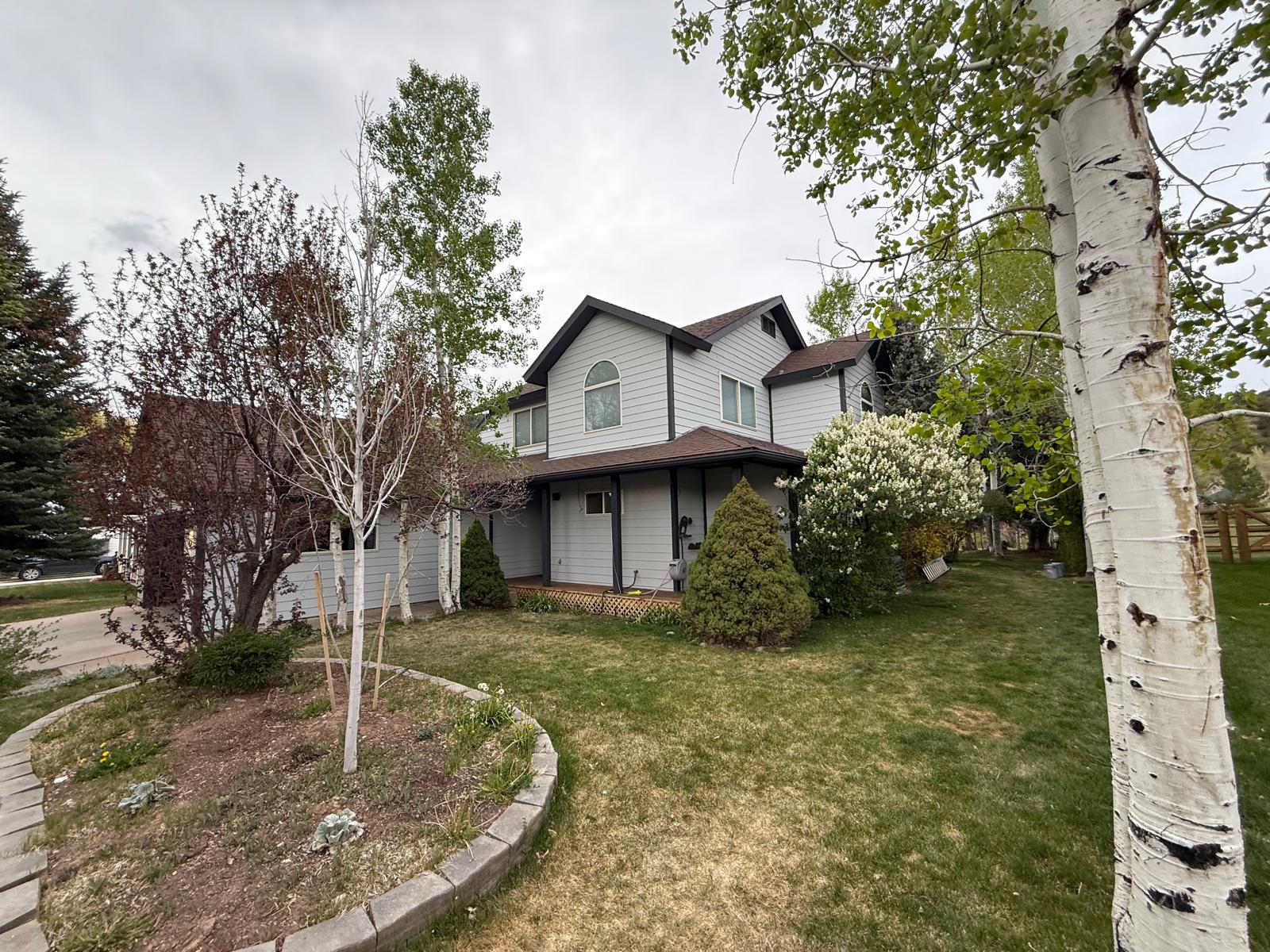 Completed house exterior and driveway approach after a full repaint — exterior painting service in Denver