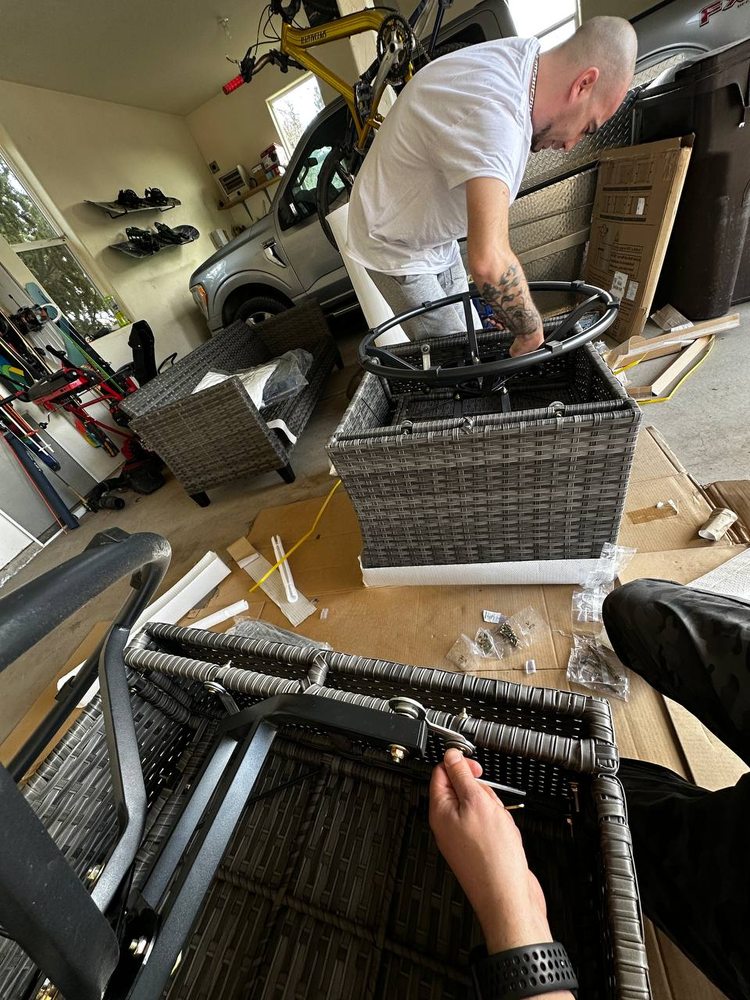 Woven outdoor chair set being assembled in a garage workspace — furniture assembly service in Denver