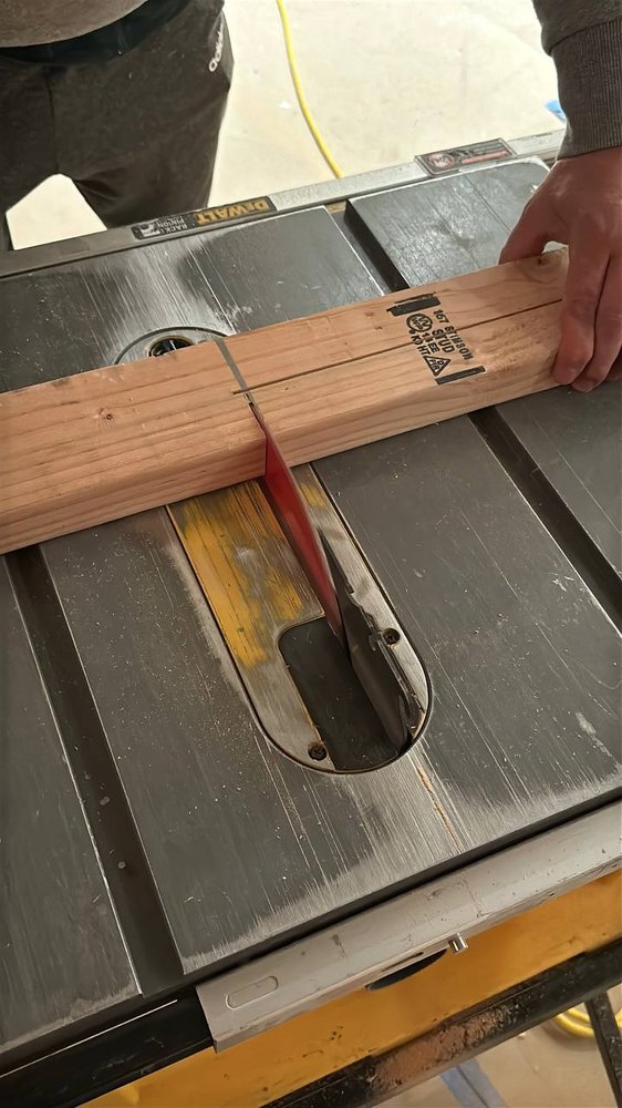 Board being ripped to width on a table saw during a carpentry job — carpentry service in Denver