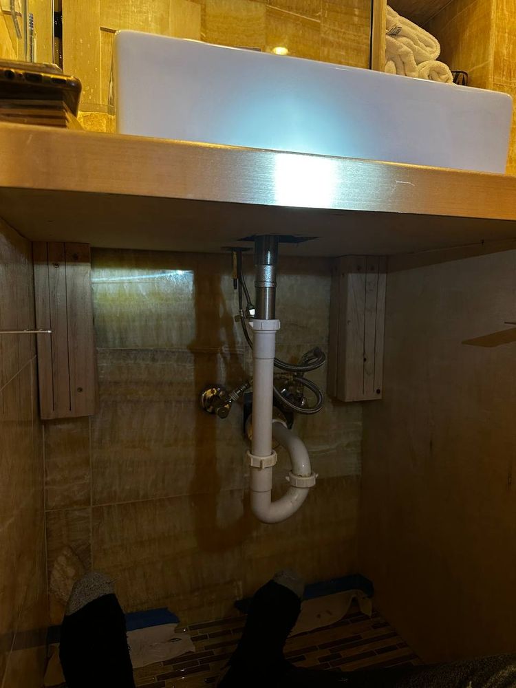 New sink trap and drain plumbing fitted under a vanity — plumbing repair service in Denver
