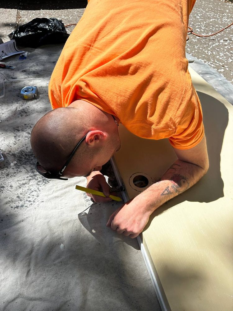Technician marking a precise cut line on a worktop before trimming — carpentry service in Denver