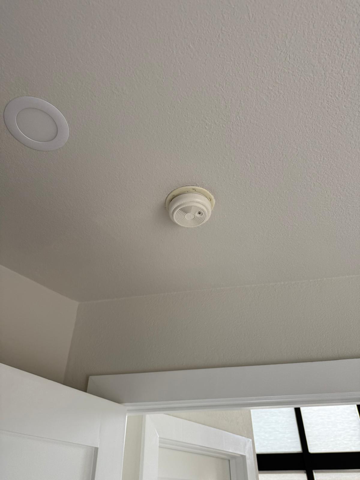 Smoke alarm mounted and sealed to a smooth finished ceiling — fixture installation service in Denver