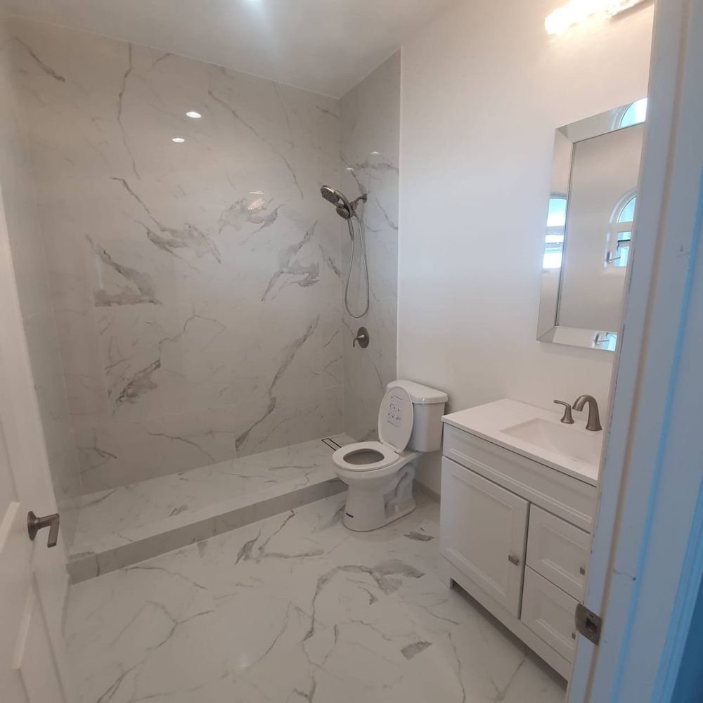 Finished bathroom with a marble-look tiled shower, new vanity and fixtures — bathroom tiling and grout service in Denver